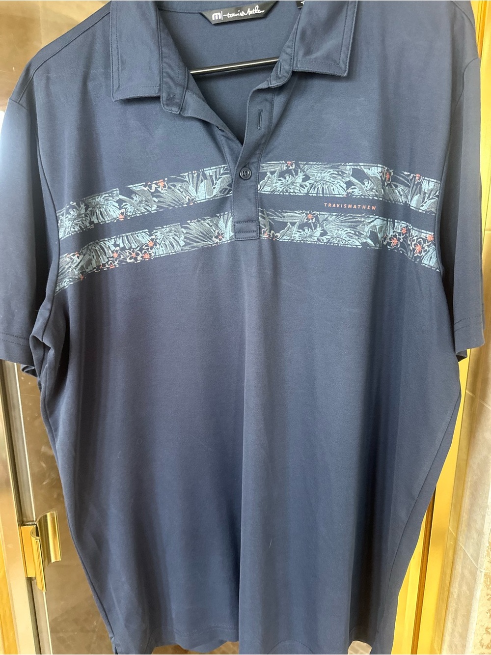 Travis Mathew Navy Polo with Tropical Chest Stripes